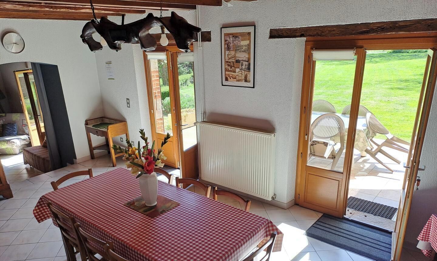 A dining area with a table set for four, a radiator, and a view of the outdoors.
