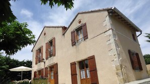 A two-story building with a beige facade, wooden shutters, and a small balcony. - La Teulière - LOMBERS - Gîte (LOMBERS)