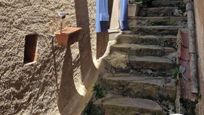A narrow stone staircase in a historic town with wooden shutters on the buildings.