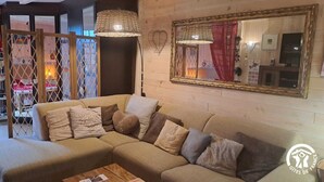 A cozy living room with a sectional sofa, two hanging wicker lamps, and a large mirror on the wall.