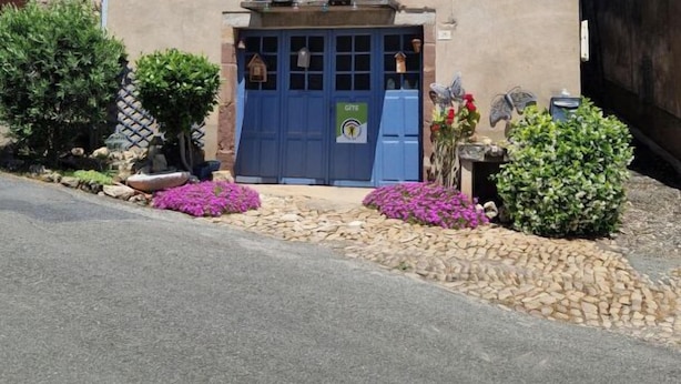 A traditional stone building with a blue door and a small balcony.