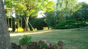 A garden with a swing set, a lawn, and a tree. - Les Barreaux - MONTVALEN (MONTVALEN)