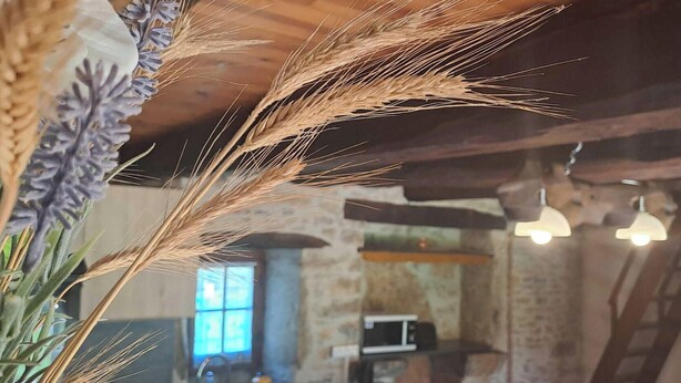 A rustic kitchen with exposed beams, a sink, and a microwave.
