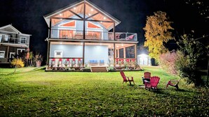 A two-story house with a balcony, a covered porch, and outdoor seating.