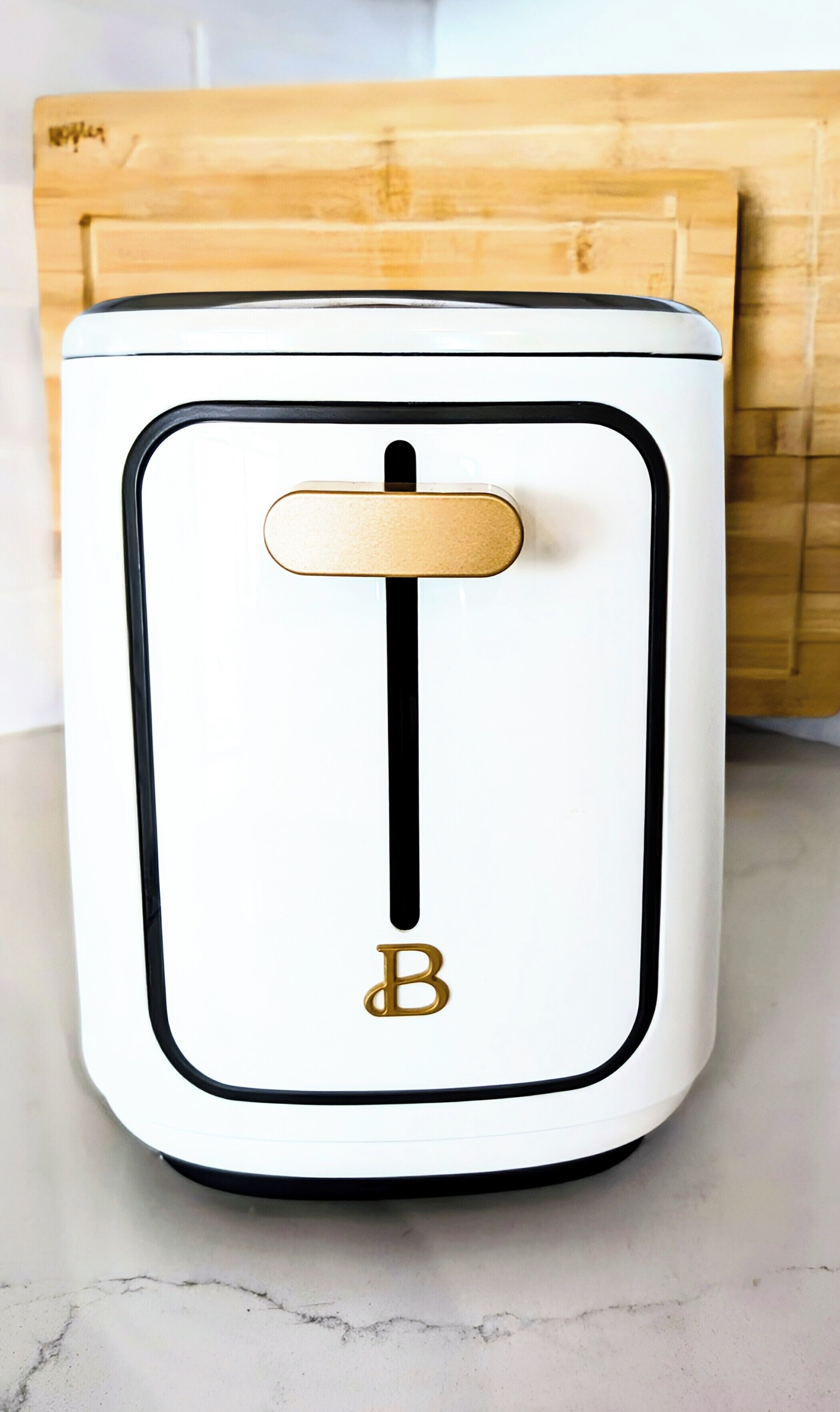 Un electrodoméstico blanco con detalles negros y un toque dorado, que presenta un logotipo de 'B' destacado.