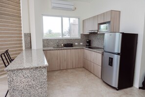 Suite Deluxe, 1 habitación, vista al mar | Cocina privada | Refrigerador, microondas y utensilios de cocina 