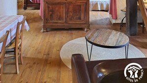 A rustic room with wooden furniture, a television, and a staircase.