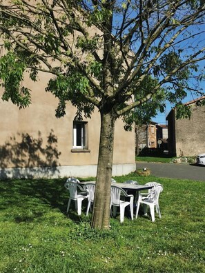 Un espace extérieur aménagé avec des arbres, une table et des chaises.
