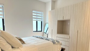 Ein Schlafzimmer mit einem Bett, einem Kleiderschrank und einem Fenster.
