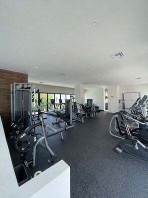 A modern gym with various exercise equipment, including treadmills, weight machines, and free weights.