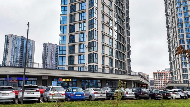 Un edificio moderno y alto con múltiples pisos y grandes ventanales.