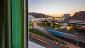 A cityscape with a multi-level highway and buildings. - Al Jisr Hotel (Muscat)