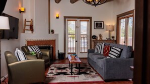 A living room with a fireplace, a sofa, a coffee table, and a TV.