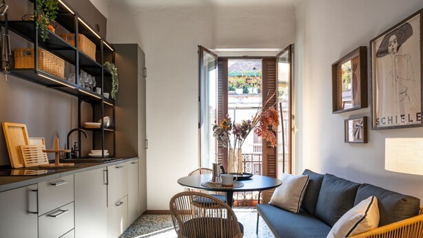 A compact living space with a kitchenette, dining area, and a sofa. - Maison Amelie – Design Apartment | Milano Centrale (Milan)