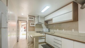 Una cocina equipada con microondas, estufa y alacenas.