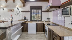 A kitchen with a dishwasher, oven, and a large window. - Holiday Home 'Isabel' with Private Pool, Wi-Fi and Air Conditioning (Conil de la Frontera)