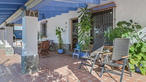 An outdoor patio area with tiled flooring, stone pillars, and wicker chairs. - Holiday Home 'Isabel' with Private Pool, Wi-Fi and Air Conditioning (Conil de la Frontera)