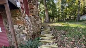 Un bâtiment en pierre avec une terrasse en bois qui mène à une maison.