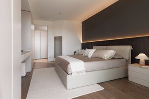 Una camera da letto moderna con un letto grande, comodini, un tavolino e uno specchio.