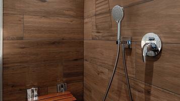 Un espace douche moderne avec un revêtement mural en bois, une douchette à main et un panneau de commande fixé au mur.