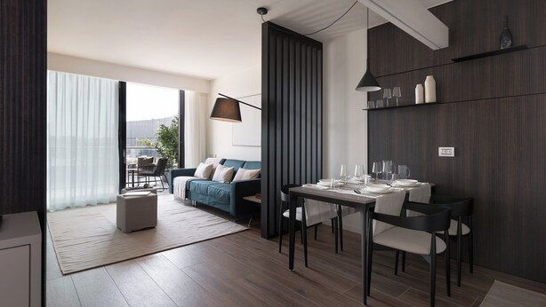 Un salon moderne avec un coin repas, comprenant un canapé, une table à manger pour quatre personnes et une grande fenêtre.