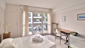 Ein Hotelzimmer mit Bett, Schreibtisch, Stuhl und Blick auf den Balkon.