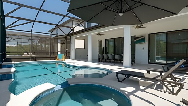 En moderne indendørs swimmingpool med glasloft, liggestole og ventilator.