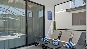 Et moderne loungeområde med glasvægge, et blåt skilt og lounge stole med stribede hynder.
