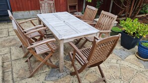 A wooden table and chairs set on a stone patio with a red fence and potted plants in the background. - Central Location, Sleeps 7, 4 Bedrooms, Parking for 4+ cars, easy walk to town (Stratford-upon-Avon)