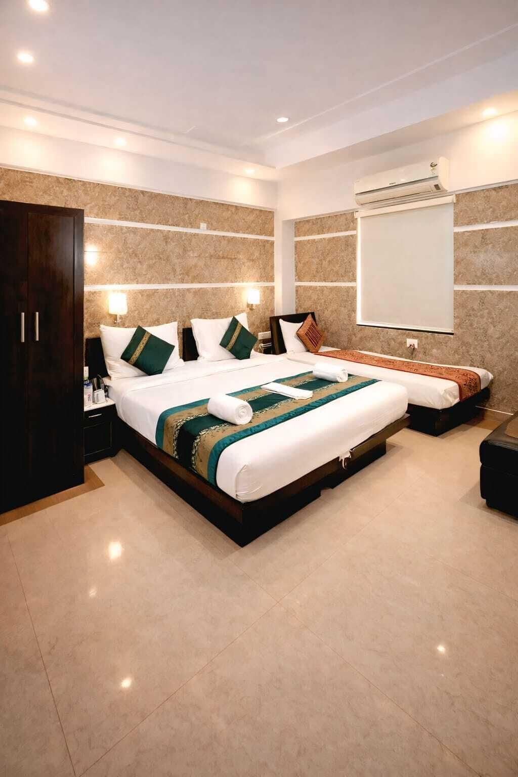 Una habitación de hotel moderna con una cama grande, un armario, una mesita de noche y un ventanal amplio.