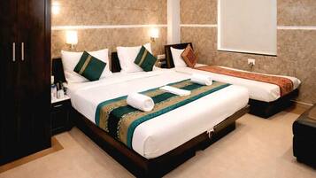 Una habitación de hotel moderna con una cama grande, un armario, una mesita de noche y un ventanal amplio.