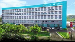 Um edifício hospitalar com design moderno, com vários andares e um esquema de cores azul e branco marcante.
