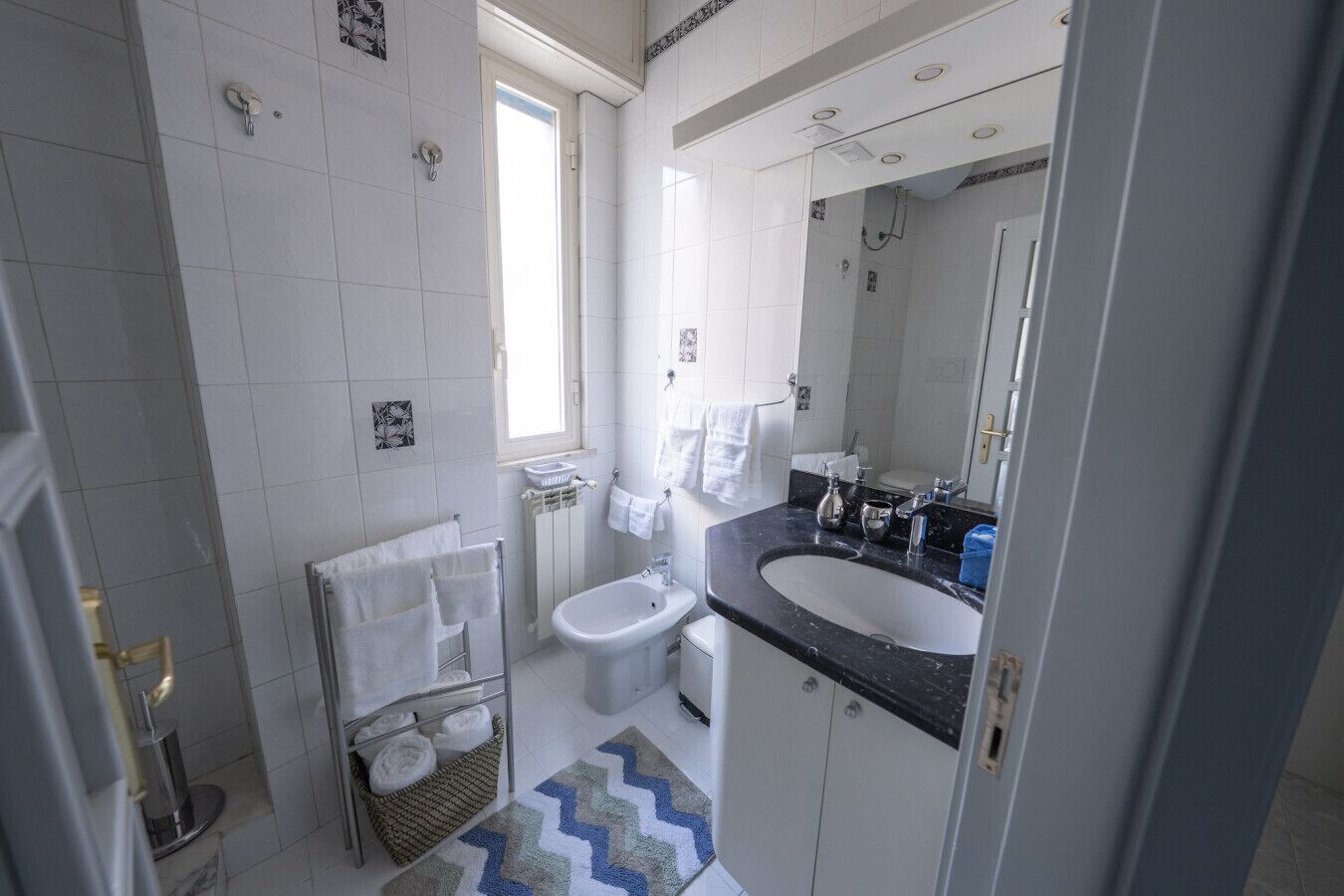 A modern bathroom with a black countertop sink, a white toilet, and a shower area.