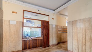 A hallway with wooden paneling, a wooden door, and a bulletin board with papers. - MARINELLI HOUSE - Song'Parthenope - Naples (Napoli)