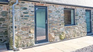 A stone building with a sign reading "SAUNA" above a door. - 2 Trem Y Mor (Holyhead)