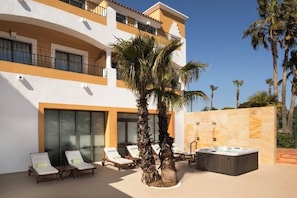 A modern hotel with a pool area, lounge chairs, and a hot tub. - Palacio de Sancti Petri Gran Melia (Novo Sancti Petri)
