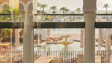 A pool area with lounge chairs and tables, surrounded by a railing.