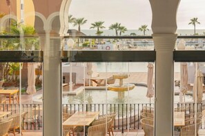 A pool area with lounge chairs and tables, surrounded by a railing.