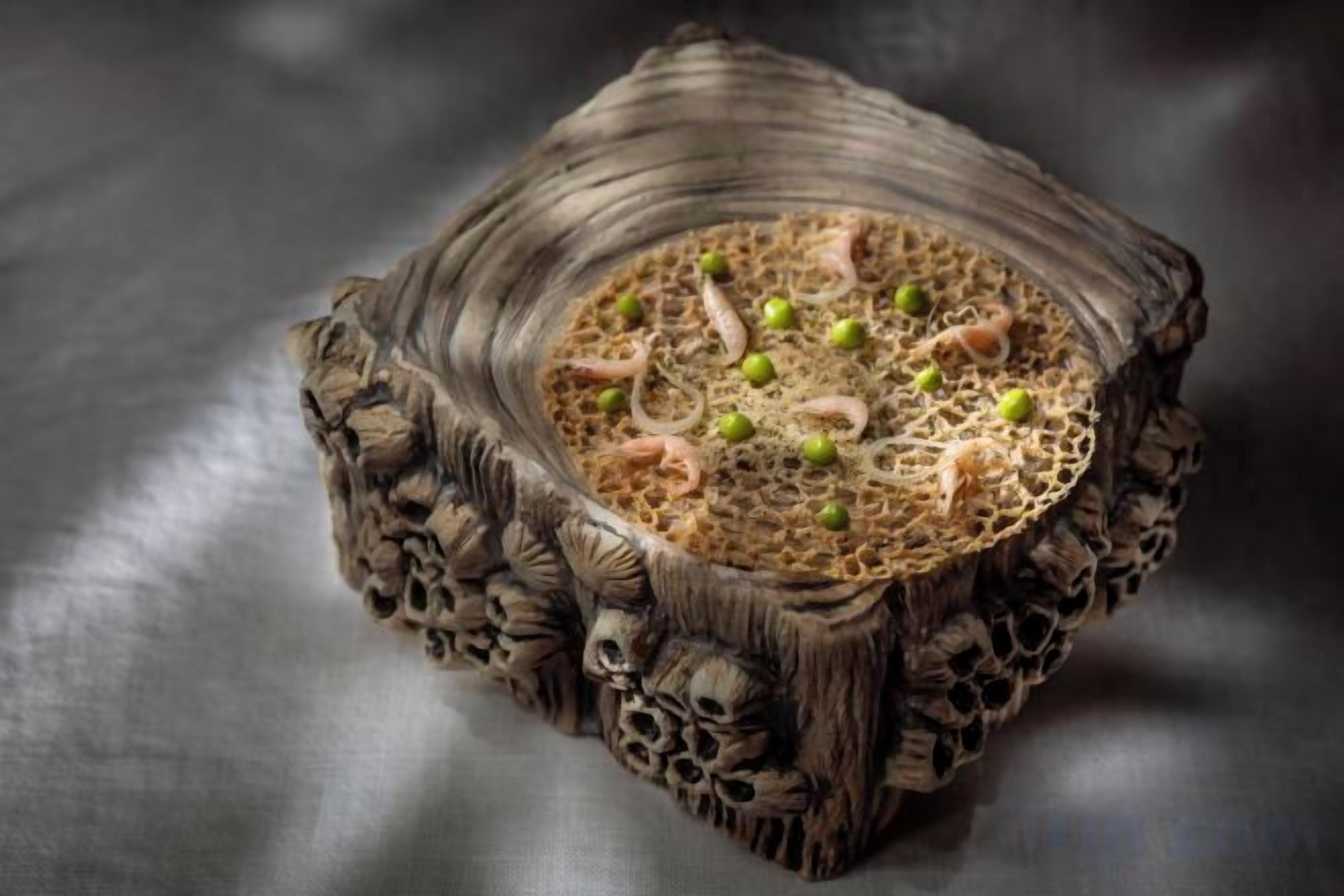 Un cuenco de madera tallada con superficie texturizada y una hendidura central, posiblemente para contener alimentos o bebidas.