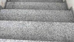 A staircase with a handrail on both sides, leading to an interior space.