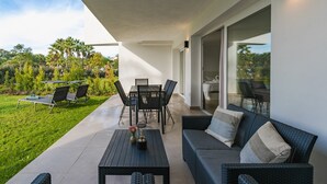 Une terrasse extérieure avec une table à manger, des chaises, un canapé et une table basse.