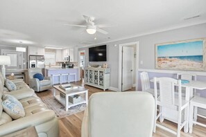 Una sala de estar moderna con un sofá, una mesa de centro y un televisor.