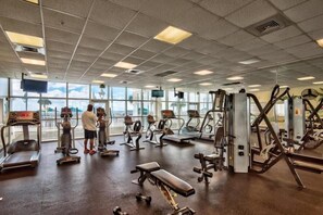 A gym with treadmills, weight machines, and benches.