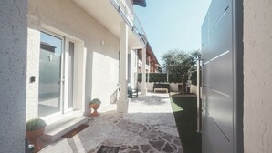 A stone-paved patio with a bench, potted plants, and a clear view of the surrounding buildings. - Casa da Victoria - Apartment 1 (Castrezzato)