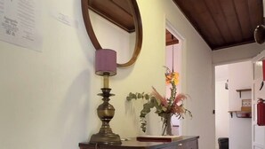 A wooden dresser with a mirror and a lamp in a hallway with wooden floors and a wooden ceiling. - Charming Apartment with River Views & Sunny Terraces near Lisbon (Vila Franca de Xira)