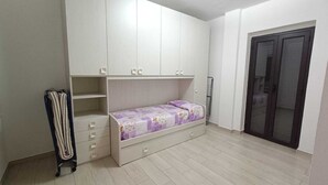 Un dormitorio con cama, armario y puerta.