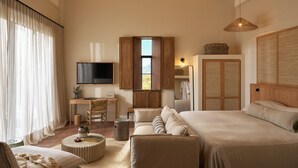 A spacious bedroom with a large bed, a desk, and a television. - The Alexander Estate (Cape Town)