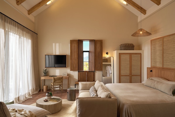 A spacious bedroom with a large bed, a desk, and a television. - The Alexander Estate (Cape Town)
