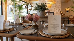 A dining table set with plates, cutlery, and a menu. - The Alexander Estate (Cape Town)