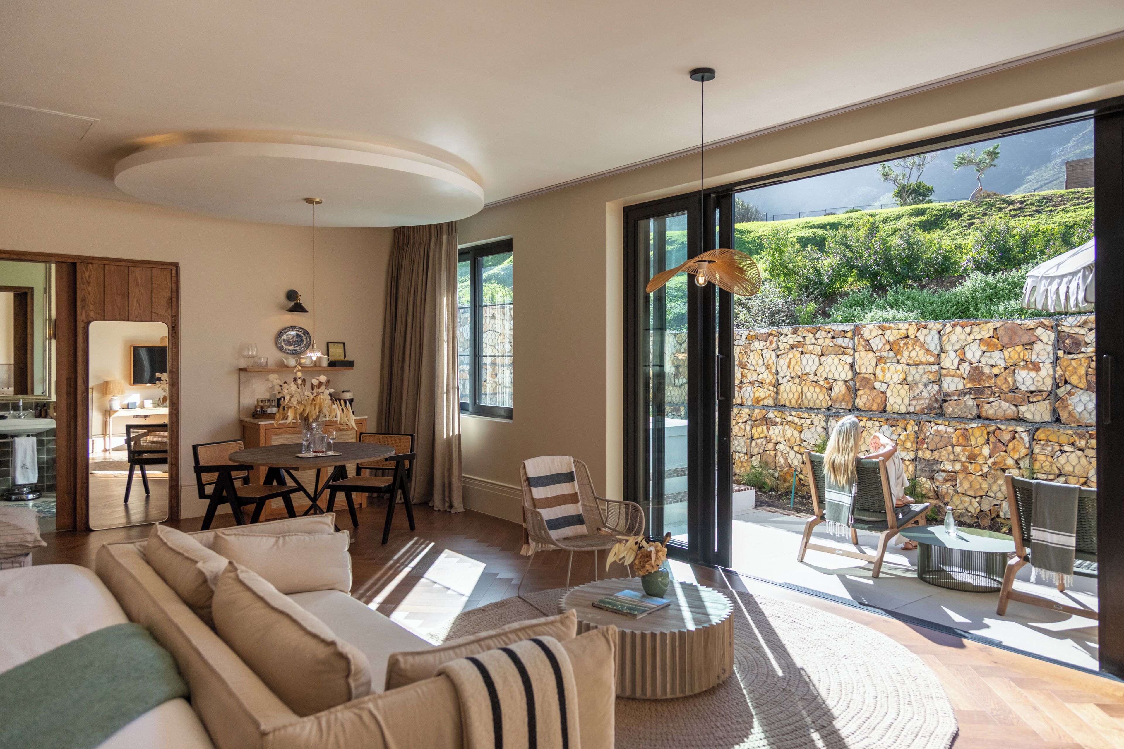 A spacious living area with a large window, a dining table, and a cozy seating arrangement.